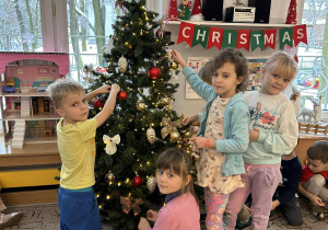 Dzieci dekorują choinkę