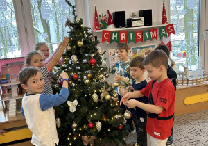 Dzieci ubierają choinkę