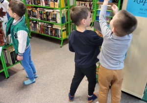 Dzieci szukają symboli Łodzi na półkach