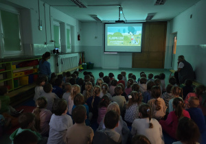 Dzieci na sali gimnastycznej oglądają film