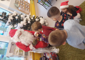 św. Mikołaj rozdaje dzieciom prezenty