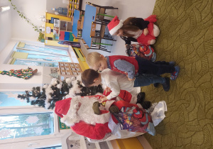 św. Mikołaj rozdaje dzieciom prezenty