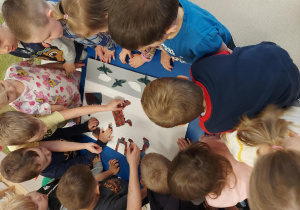 Dzieci układają materiały na tkaninie