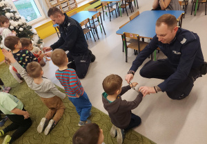 Dzieci przymierzają kajdanki