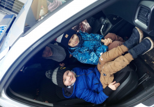 Chłopcy siedzą w radiowozie policyjnym