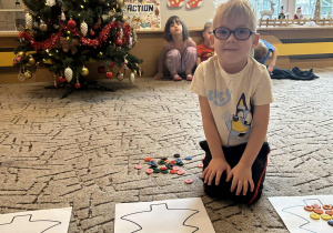 Chłopiec układa guziki na choince