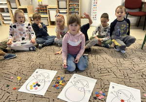 Dziewczynka układa guziki na ilustracji