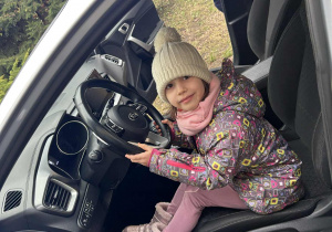 Dziewczynka siedzi w radiowozie policyjnym