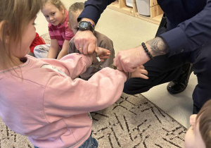 Policjant zakłada dziewczynce kajdanki