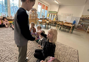 Chłopiec rozdaje smakołyki dzieciom