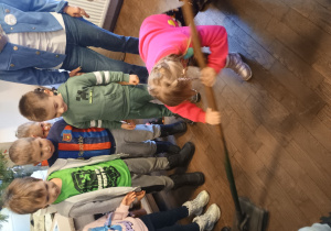 Dzieci próbują posługiwać się dawnym przyrządem do mycia podłogi