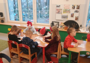 Dzieci wykonują świąteczne obrazki dla Mikołaja