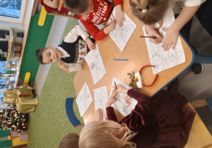 Dzieci wykonują świąteczne obrazki dla Mikołaja