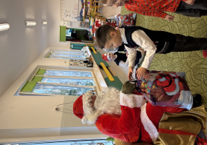 Chłopiec odbiera prezent od Mikołaja