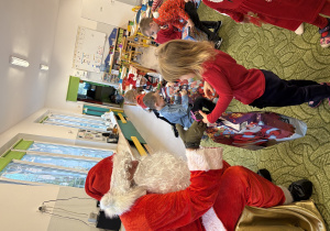 Dziewczynka odbiera prezent od Mikołaja