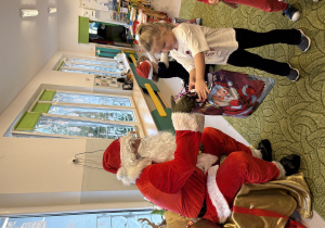 Dziewczynka odbiera prezent od Mikołaja