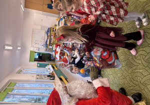 Dziewczynka odbiera prezent od Mikołaja