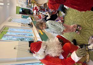 Dziewczynka odbiera prezent od Mikołaja