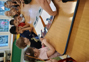 Dzieci naklejają elementy obrazu z tkanin