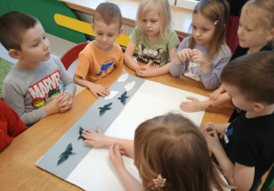 Dzieci naklejają elementy obrazu z tkanin