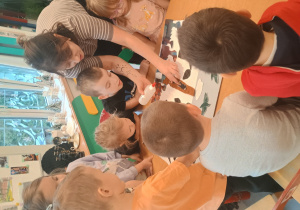 Dzieci naklejają elementy obrazu z tkanin