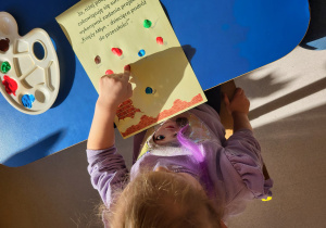 Dziewczynka odciska palec na kodeksie