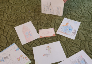 Chłopiec pokazuje rysunki dzieci