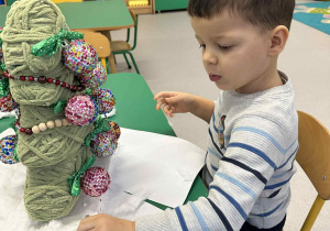 Chłopiec przykleja watę do styropianu