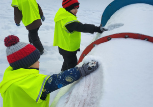 Chłopcy zrzucają śnieg z tunelu
