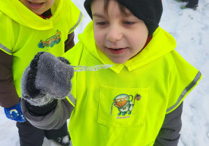 Chłopiec pokazuje znaleziony sopel lodu