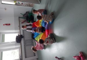 Dzieci w rytm muzyki bujają chustą