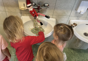 Dzieci odkrywają psotę Elfa, który sprawił, że z kranu zamiast wody leci posypka