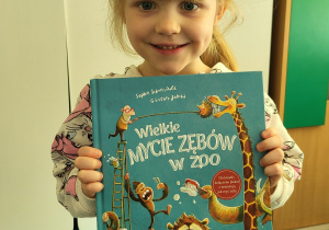 Dziewczynka trzyma w dłoniach książkę