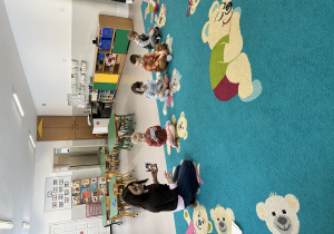 Dzieci zapoznają się ze zdjęciami, które prowadząca szczegółowo omawia