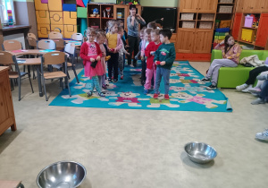 Dzieci celują kulkami z papieru do miski