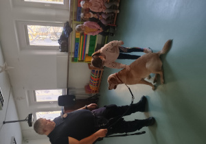 Dziewczynka głaszcze psa