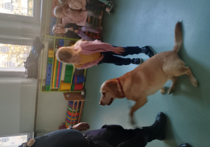 Dziewczynka głaszcze psa