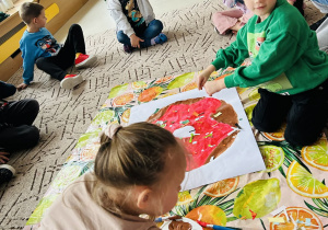 Dzieci ozdabiają pączka