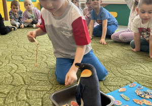 Chłopiec karmi pingwina rybkami