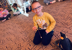 Chłopiec karmi pingwina rybkami