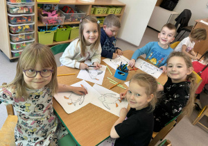 Dzieci wykonują zadania przy stolikach