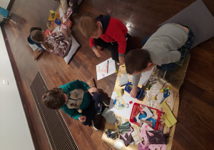 Dzieci wycinają, przyklejają i kolorują