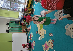 Dzieci rozkładają składniki na żulik na dywanie