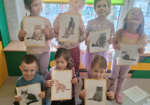 Dzieci prezentują zdjęcia kotów i ich ras