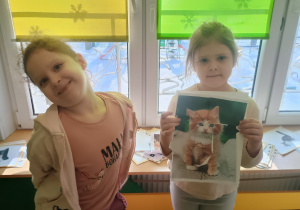 Dzieci prezentują ułożone kocie puzzle