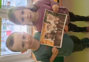 Dzieci prezentują ułożone kocie puzzle