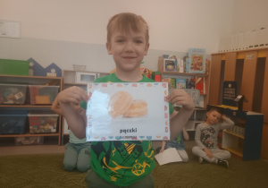 Chłopiec prezentuje obrazek pączków i przysmaków w innych krajach