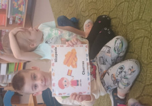 Chłopiec prezentuje obrazek pączków i przysmaków w innych krajach