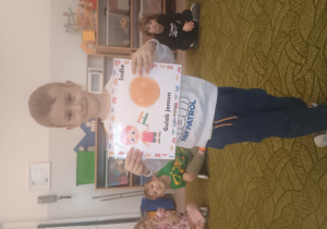 Chłopiec prezentuje obrazek pączków i przysmaków w innych krajach