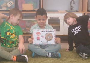 Chłopiec prezentuje obrazek pączków i przysmaków w innych krajach